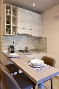 una cucina con un grande tavolo in legno con sedie di Casa vacanza "Glicine" Taormina-Trappitello a Taormina