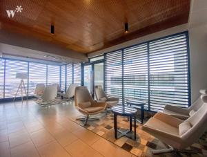 a waiting room with chairs and tables and windows at Navarrete Residence in Premium San Isidro by Wynwood House in Lima