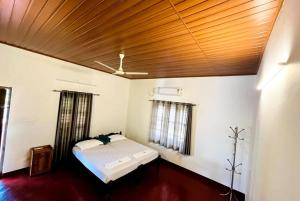 a bedroom with a bed and a wooden ceiling at Marari Oceanscape in Alleppey