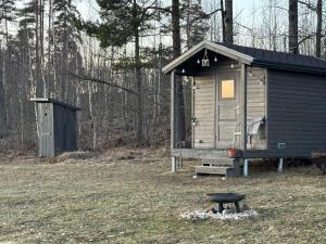 a small cabin in the middle of a field at Mazie Salnēni in Vecpiebalga