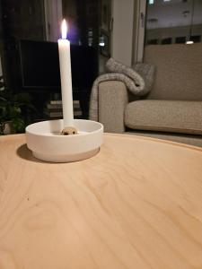 a candle sitting on top of a wooden table at Ny og moderne leilighet, midt i byen1 in Trondheim