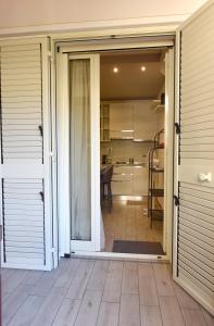 una porta scorrevole in vetro che conduce a una cucina con tavolo di Casa vacanza "Glicine" Taormina-Trappitello a Taormina