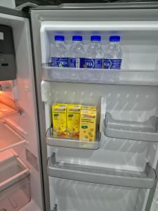 an open refrigerator with bottles of water and milk at Teratak Che Esah Guest House FREE WIFI NETFLIX in Pasir Mas