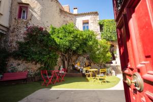 un groupe de chaises et de tables devant un bâtiment dans l'établissement La Tour Du Terroir, à Rivesaltes