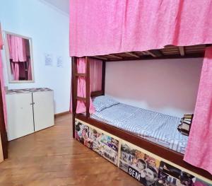 1 dormitorio con litera y cortinas rosas en Red Monkey Hostel Barra Funda en São Paulo