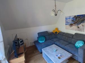 a living room with a blue couch and a table at Haus Erika in Prerow