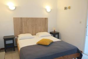 a bedroom with a bed with a yellow pillow on it at Domaine Bocca di Feno in Bonifacio