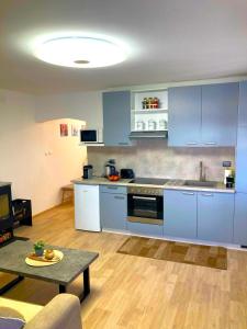 una cocina con armarios azules y una mesa en una habitación en Apartman Kažun, en Poreč