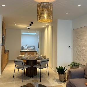 Una sala de estar con mesa y sillas y una cocina. en Gezellig appartement Liva, en Blankenberge