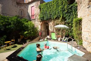 a group of people playing in a swimming pool at La Tour Du Terroir in Rivesaltes