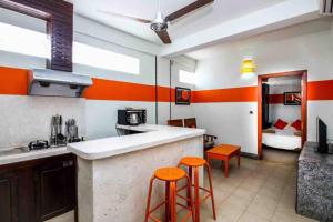 a kitchen with orange and white walls and orange stools at CHILCHILL Elite Residences BKK2 in Phnom Penh