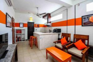 un soggiorno con pareti bianche e arancioni e una cucina di CHILCHILL Elite Residences BKK2 a Phnom Penh