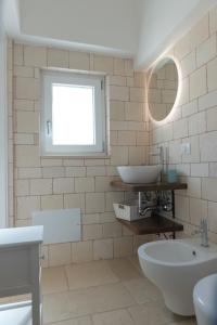 uma casa de banho com um lavatório e um espelho em Masseria Carperi in the heart of Valle d'Itria em Cisternino