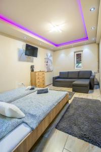 sala de estar con 2 camas y sofá en Partyház Gödöllő, en Gödöllő