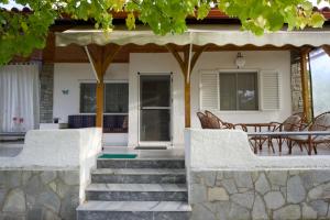 Casa con porche con mesa y sillas en Almira Villa on Trani Αmmouda beach, en Agios Nikolaos