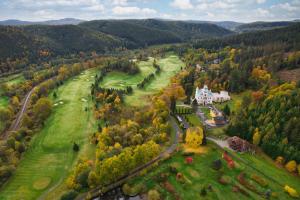 an aerial view of a house in a field with trees at Pension U Golfu Cihelny in Karlovy Vary