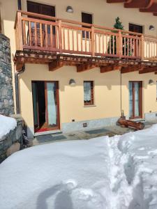 a house with a wooden deck on top of snow at PUNTA VITTORIA SUB 14 - RESIDENCE ANDERBATT GRESSONEY - 3 locali - CIR N 0010 in Staval