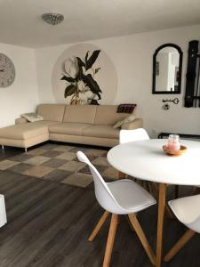 ein Wohnzimmer mit einem Sofa, einem Tisch und Stühlen in der Unterkunft Einliegerwohnung in Gissigheim. in Königheim