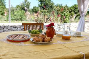 un tavolo con un piatto di prodotti da forno e succo d'arancia di Agriturismo Masseria San Basilio a Giurdignano
