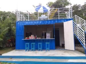 ein blaues Gebäude mit Hockern davor in der Unterkunft Tanjong Tinggi Cottage in Sijuk