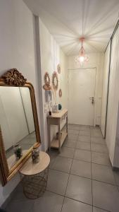 a hallway with a large mirror and a table at Appartement T2 cosy et calme in Bayonne
