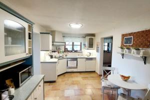 a kitchen with white cabinets and a table in it at Naturjuwel inmitten der Weinberge in Sankt Stefan ob Stainz