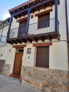 budynek z balkonem i drzwiami w obiekcie La Casa de Mi Abuela w mieście Aldeanueva del Camino