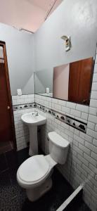 a bathroom with a toilet and a sink at Hospedaje dominguez in Oxapampa