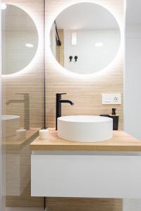 a bathroom with a white sink and a mirror at Lux&Cool Parque Nicolás Salmerón in Almería