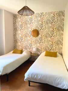 two beds in a room with a wall at Jardín privado # Netflix # 500m de la playa in Vera
