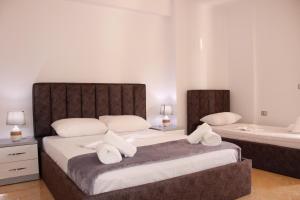 um quarto com 2 camas e almofadas brancas em ElMar Apartments em Saranda