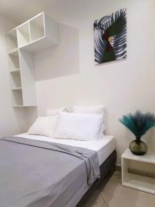 a bedroom with a bed with a picture on the wall at Studio pour 2 personnes proche de l'hôpital et du jardin de l'état in Saint-Denis