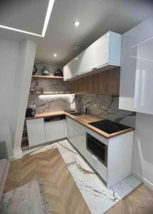 a kitchen with white cabinets and marble counter tops at Appartement Malesherbes Paris in Paris