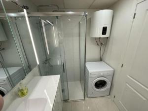 a bathroom with a washing machine and a washer at Apartment Monserrate K atico in Torrevieja