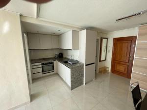 a kitchen with white cabinets and a stove top oven at Apartment Monserrate K atico in Torrevieja