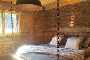 una camera con letto a dondolo in una baita di tronchi di Le Chalet de Bequi a Bellefontaine