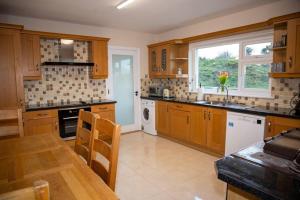 a kitchen with wooden cabinets and a table and a window at Forkfield Country House in Westport