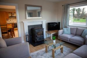 a living room with a couch and a stove at Forkfield Country House in Westport