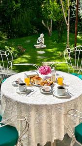 uma mesa branca com comida e flores em Hotel Villa Inés Mendoza em Mendoza