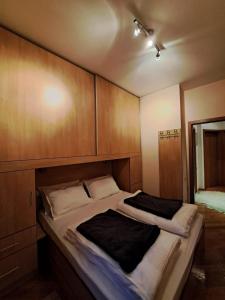 a large bed in a room with wooden cabinets at Centar 1 in Karlovac