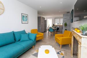 sala de estar con sofá azul y sillas amarillas en Le cœur de l'eau, en Vittel
