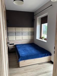 um quarto com uma cama azul e uma janela em Błękitne Wierchy em Murzasichle