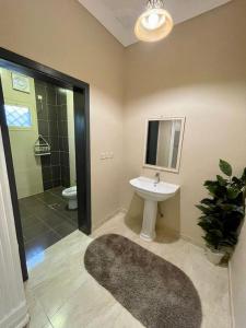 ein Badezimmer mit einem Waschbecken, einem WC und einem Spiegel in der Unterkunft استراحة شادن in Yanbu