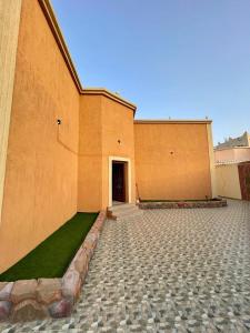 un grande edificio in mattoni con una porta e erba verde di استراحة شادن a Yanbu
