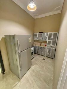 eine Küche mit einem Kühlschrank und Schränken aus Edelstahl in der Unterkunft استراحة شادن in Yanbu