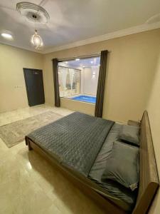 un grande letto in una stanza con una grande finestra di استراحة شادن a Yanbu