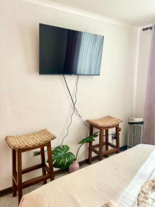 a bedroom with two stools and a tv on the wall at Espectacular Depto en Pucon 5 Estrellas in Pucón