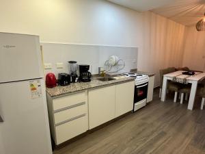 uma cozinha com um lavatório, um fogão e um frigorífico em BuenaVid estancias 2 em Cafayate