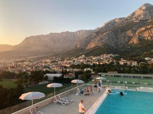 uma piscina com vista para uma cidade e montanhas em Uzelac apartment with pool em Makarska