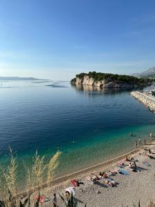 um grupo de pessoas em uma praia na água em Uzelac apartment with pool em Makarska